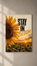 A giant sunflower beside a sunflower field at sunset with STAY IN BLOOM lettering, poster on a plain wall