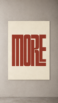 The word MORE in tall, interlocking rust-red letters on a cream background, poster on a plain wall